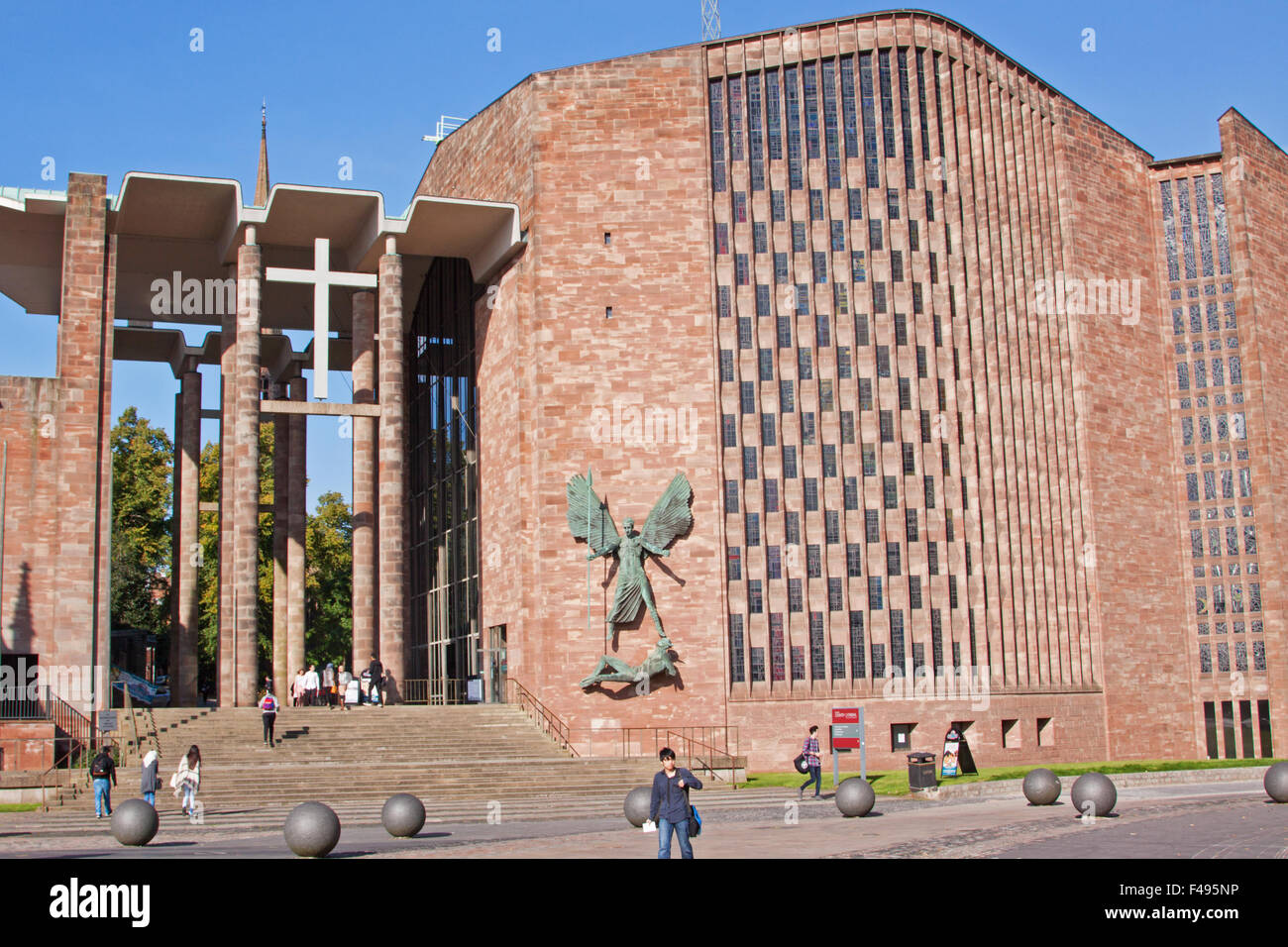 Il portico e ingresso alla cattedrale di Coventry, con virus di Epstein della statua di San Michele in trionfo su il diavolo che ornano una parete Foto Stock