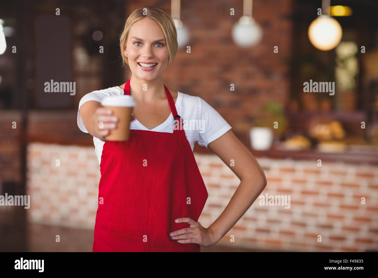 Bella cameriera di consegnare una tazza di caffè Foto Stock