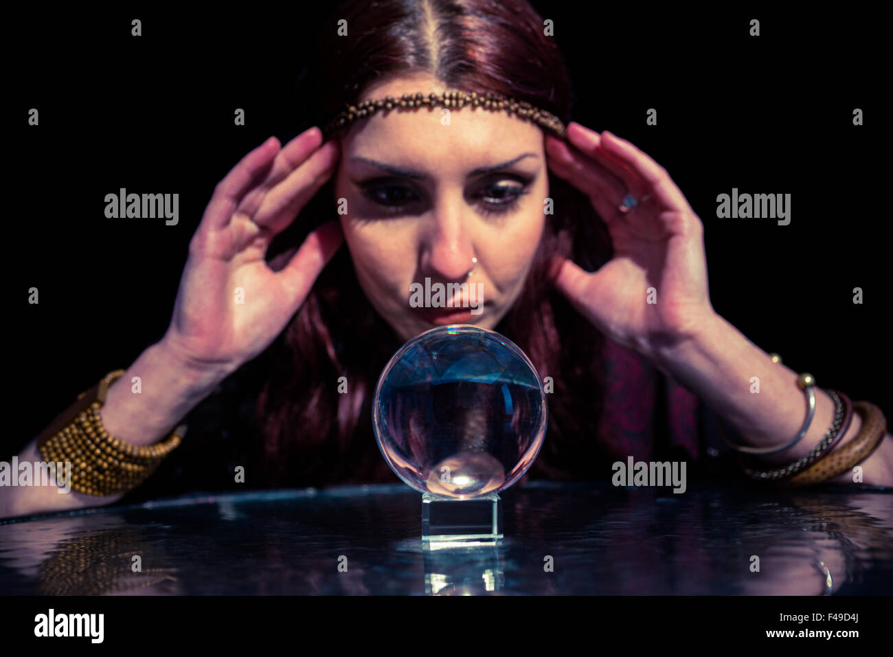 Gravi fortune teller guardando a sfera di cristallo Foto Stock