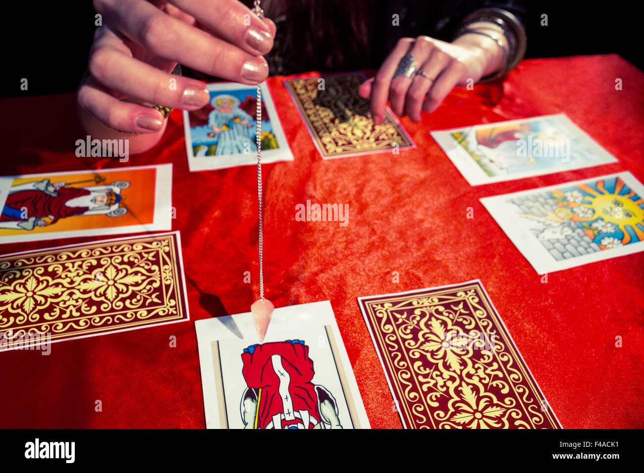 Immagine ritagliata di fortune teller usando pendolo Foto Stock