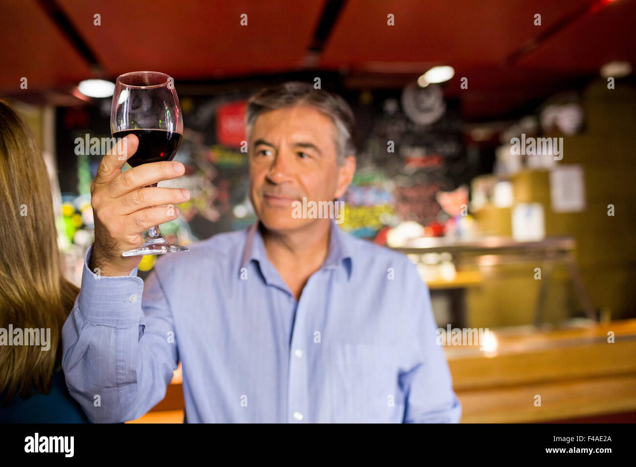 Uomo con i capelli grigi bere il vino Foto Stock