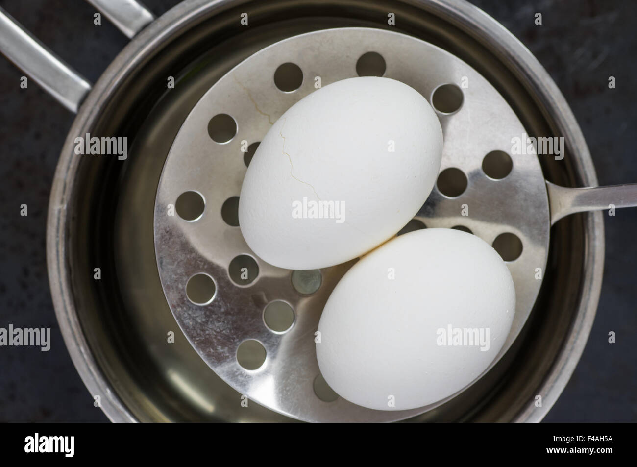 Uova skimmer ottenere dall'acqua bollente vista superiore Foto Stock