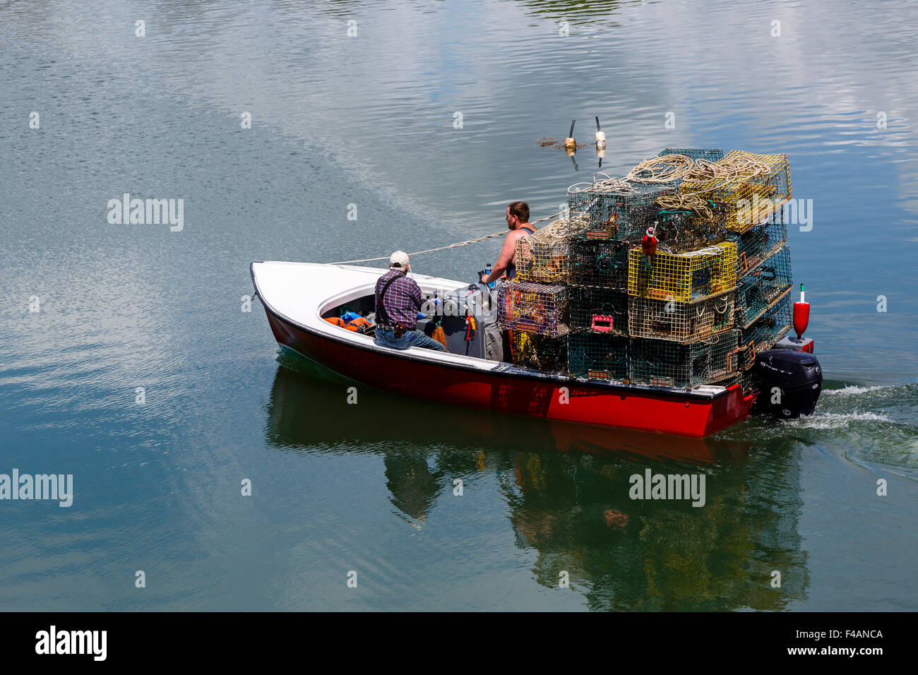 Due pescatori su piccole lobster boat impilati con aragosta pentole Harpswell Sound, Maine, Stati Uniti d'America Foto Stock