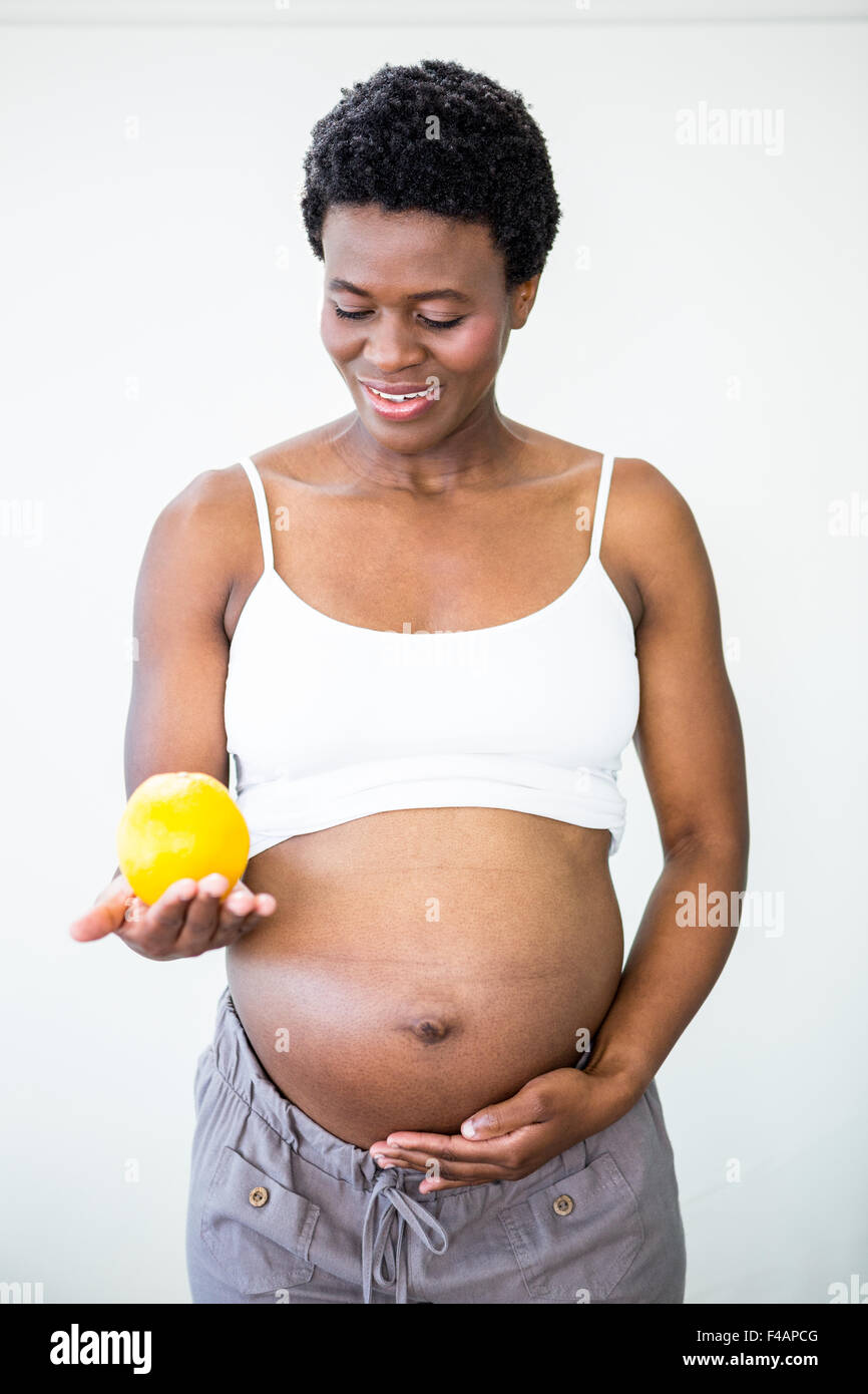 Donna incinta tenendo un limone Foto Stock