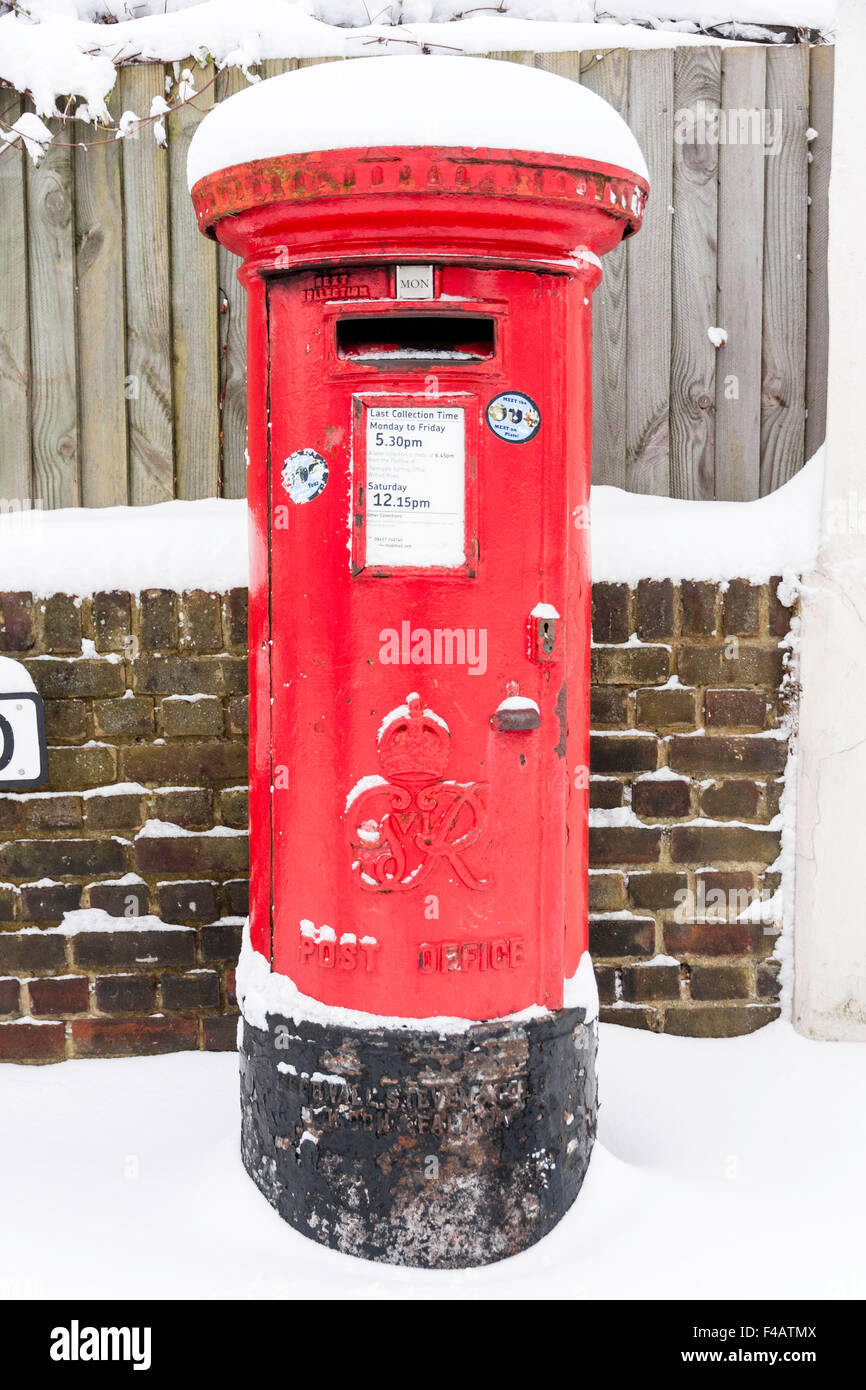 In Inghilterra. Red English Post box, (letter box, pilastro box), coperte di neve dopo la nevicata. Foto Stock