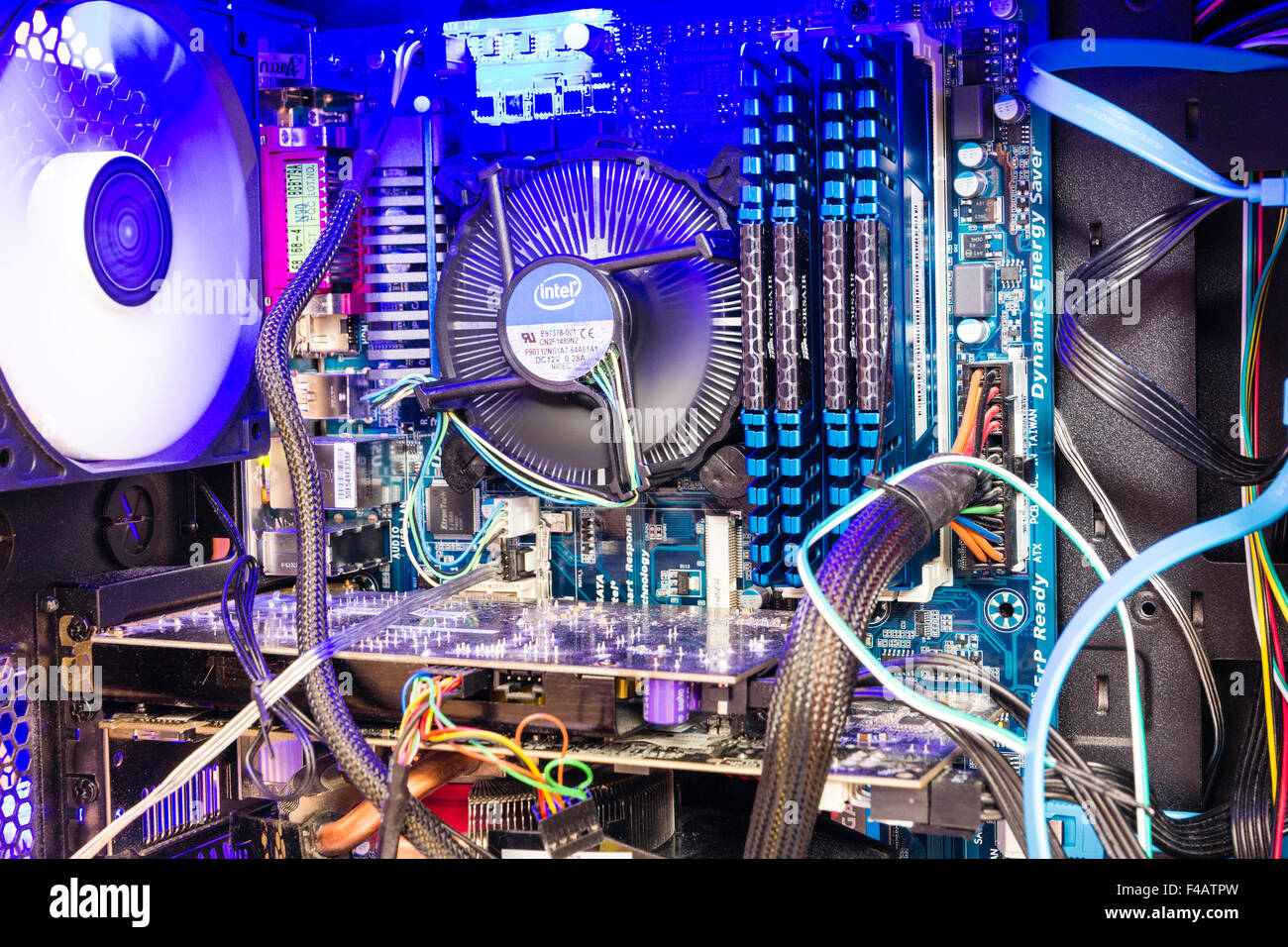 Tecnologia. Interno di aprire il computer desktop in caso. Processore principale la ventola gira interno con illuminazione blu. Banchi di memoria di RAM, cavi e fili. Foto Stock