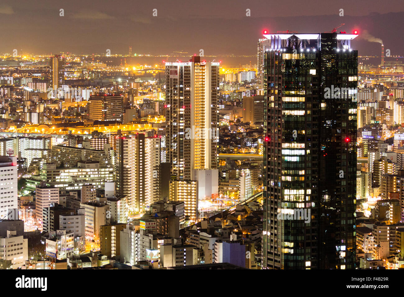 Giappone, Osaka. Vista notturna da Umeda Sky Building. Neri alti office block e vista sulla città di diversi edifici alti, illuminato brillantemente. Foto Stock