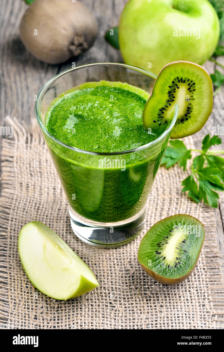 Frullato di verde in vetro sul tavolo rustico Foto Stock