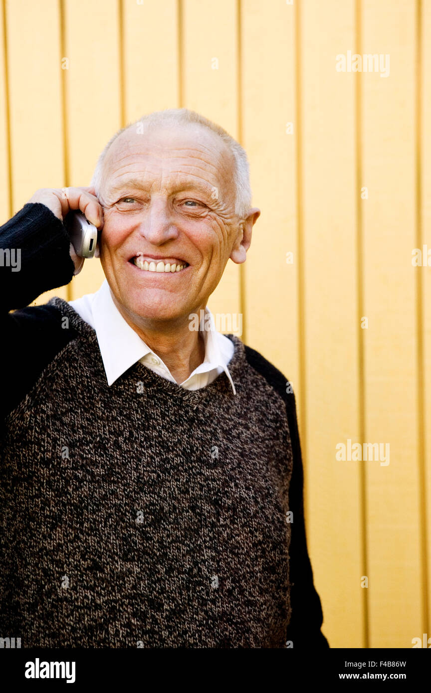 Un vecchio uomo che parla su un telefono cellulare. Foto Stock