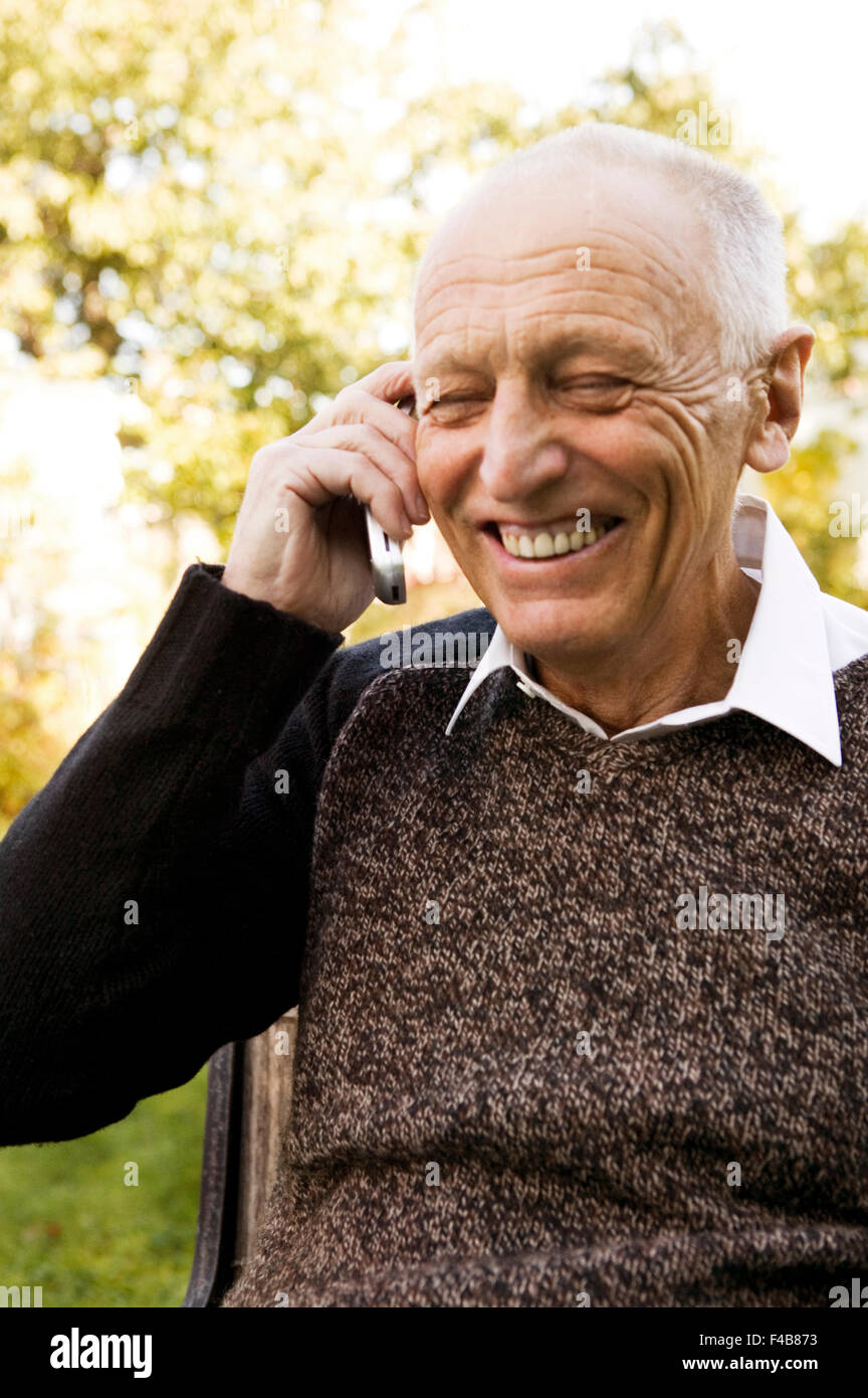 Un vecchio uomo che parla su un telefono cellulare. Foto Stock