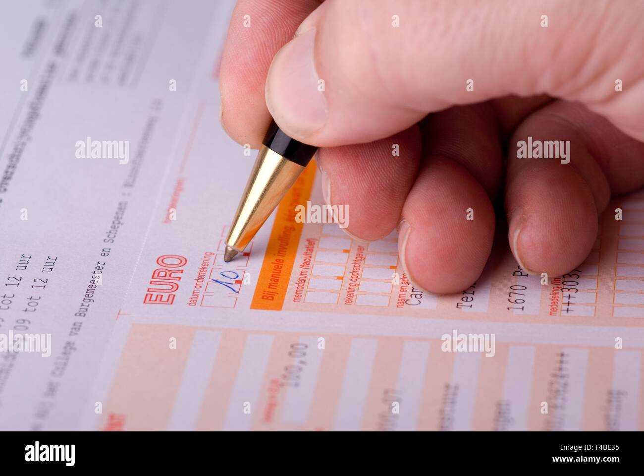 La mano di un uomo di riempimento di una banca sotto forma di trasferimento. Foto Stock