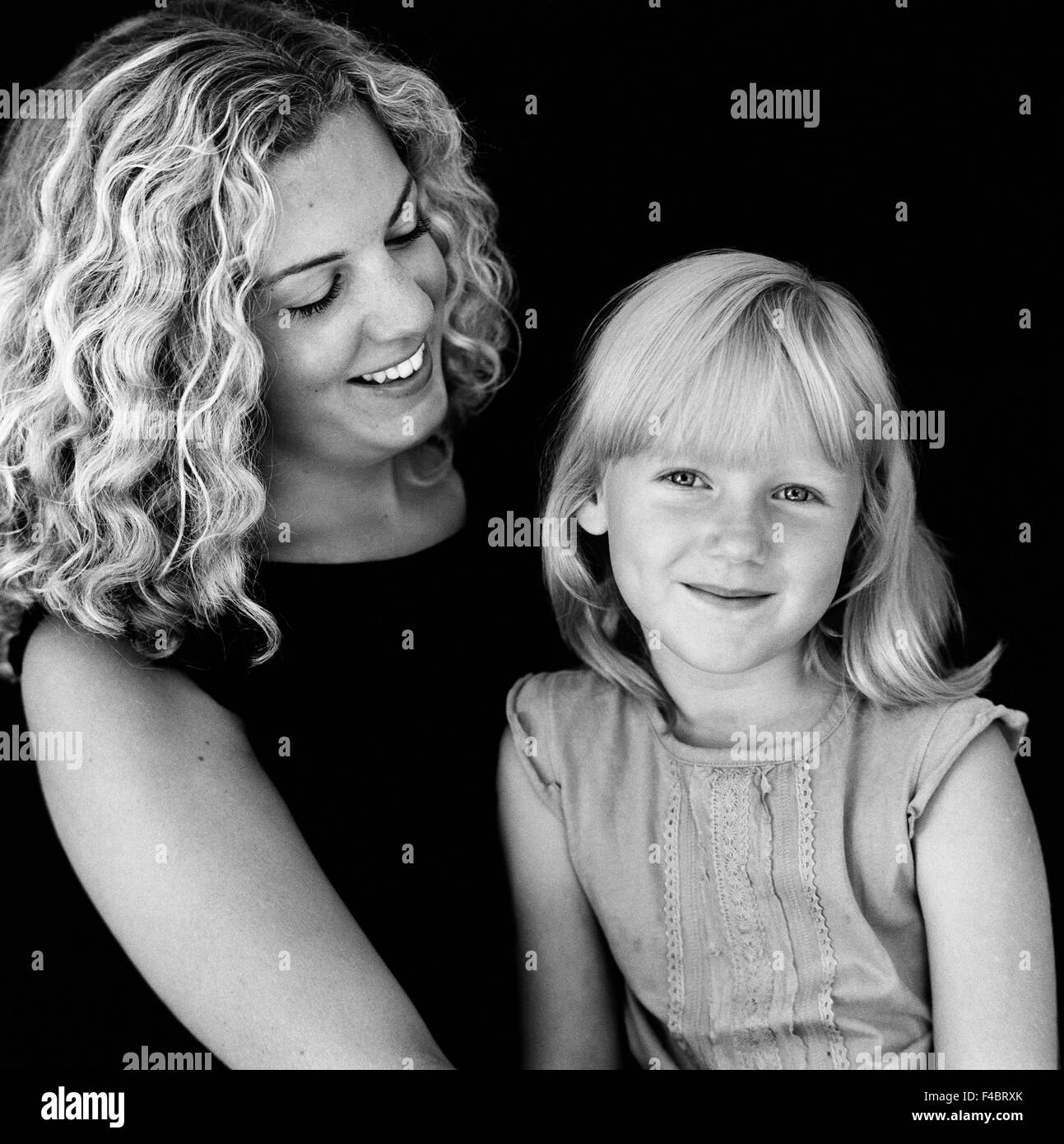 Bianco e nero vicinanza bionda figlia ragazze felicità felice in interni madre un genitore ottimismo ritratto sorride positivo Foto Stock