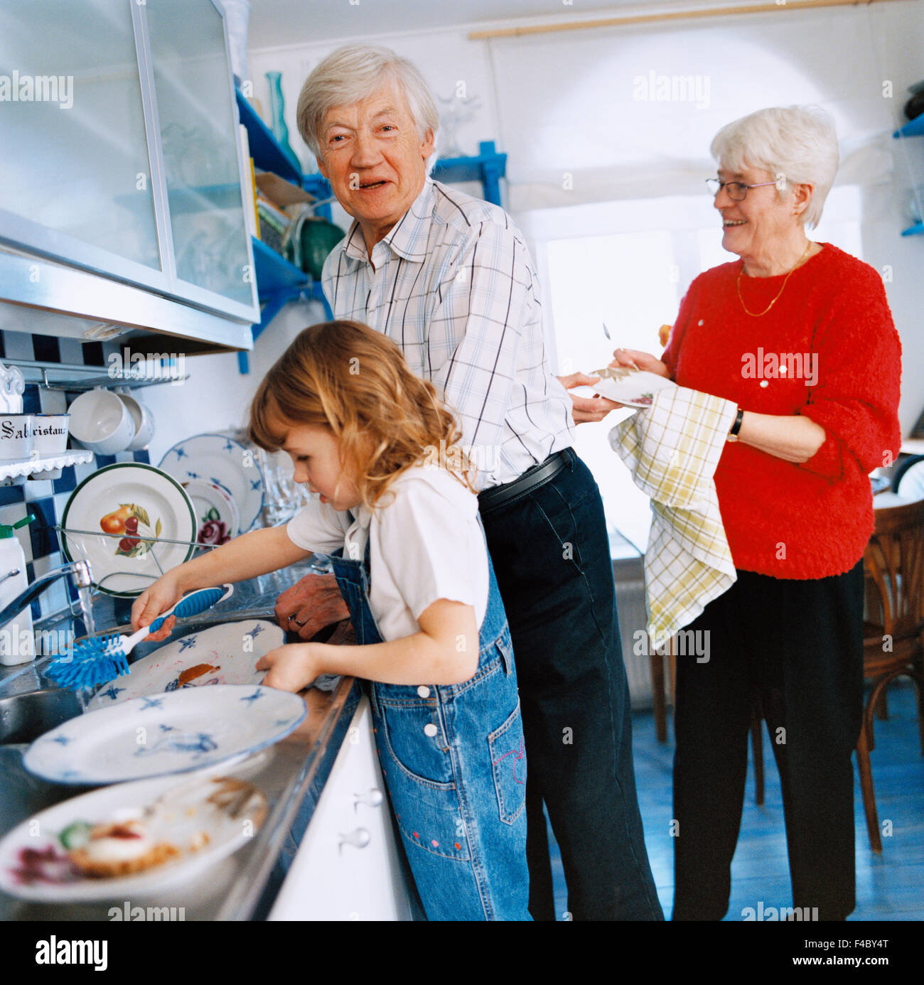 70-74 anni 75-79 anni la vicinanza di immagine a colori la cooperazione cucina domestica essiccamento anziano uomo donna anziana età elementare Foto Stock