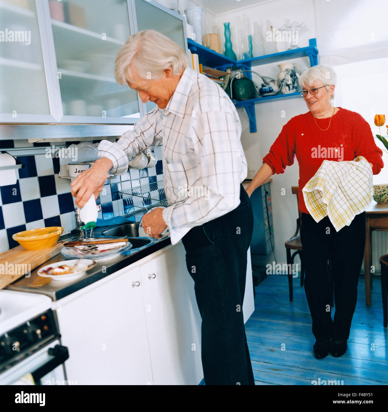 70-74 anni 75-79 anni adulti solo vicinanza immagine a colori la cooperazione cucina domestica essiccamento anziano uomo donna anziana Foto Stock
