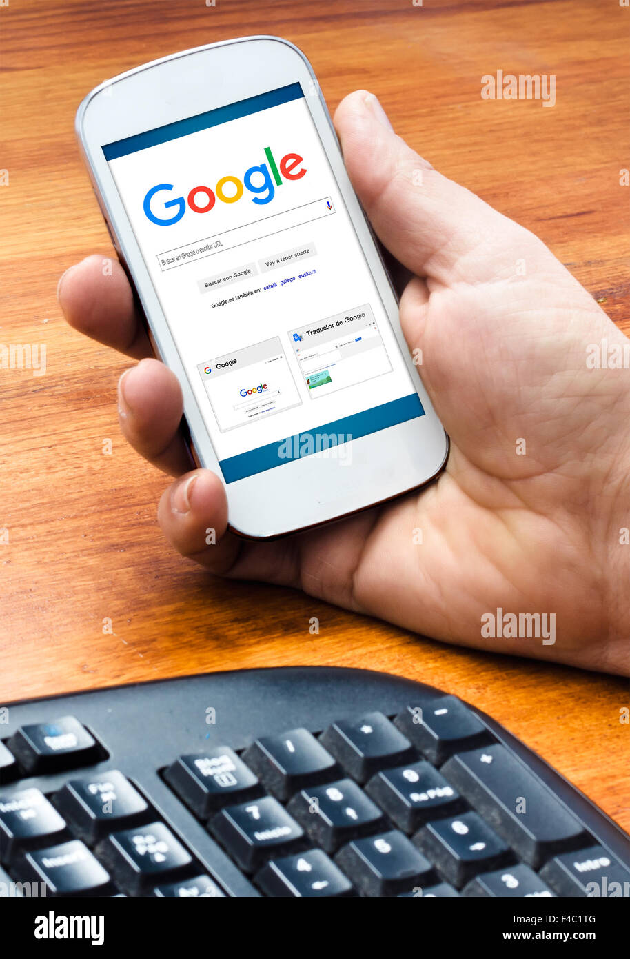 Barcellona, Spagna - 4 Settembre 2015: Maschio mano azienda sullo smartphone con Google Ricerca Web homepage sullo schermo (Nuovo Google l Foto Stock