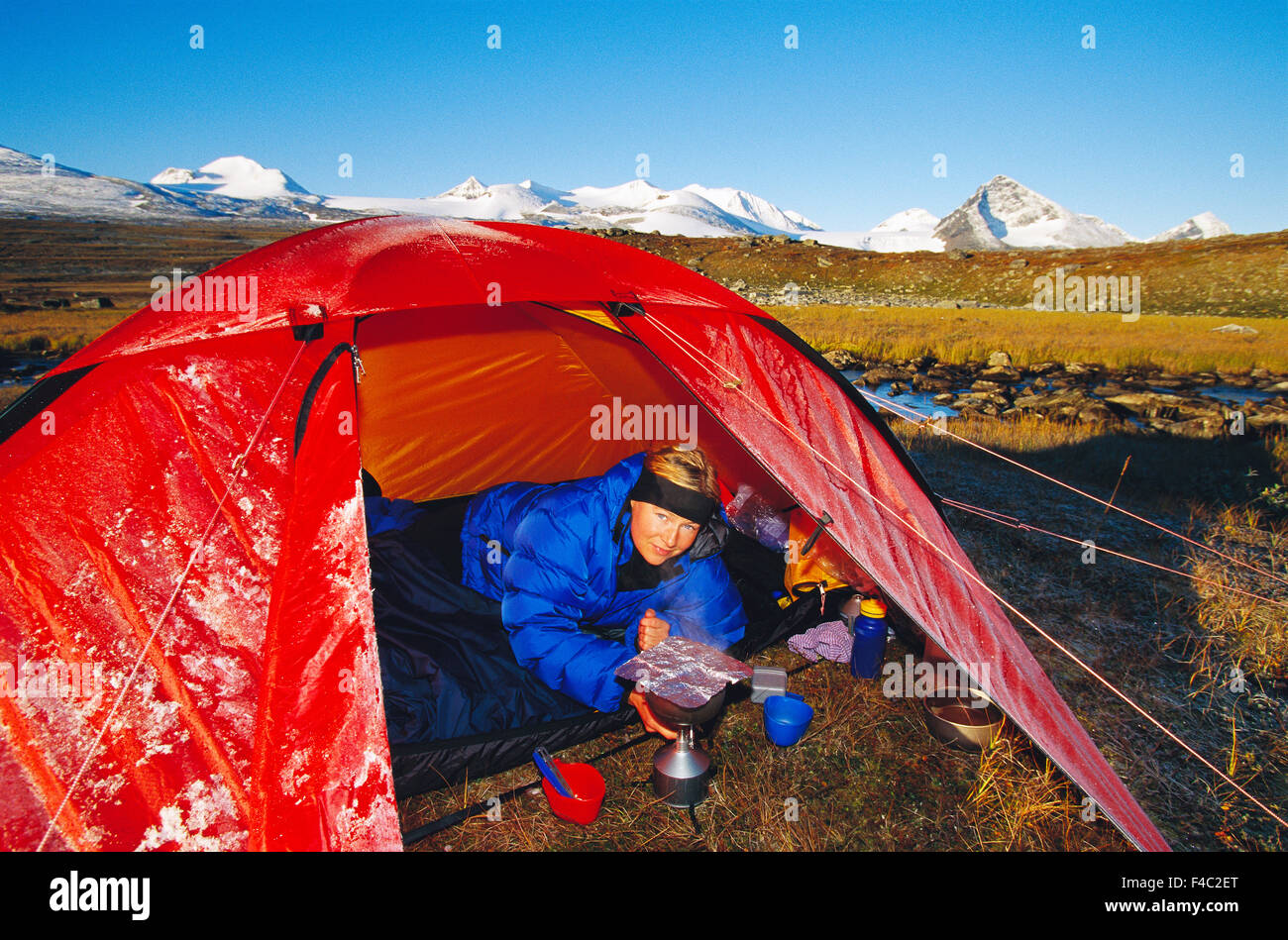 Una donna in una tenda in montagna. Foto Stock