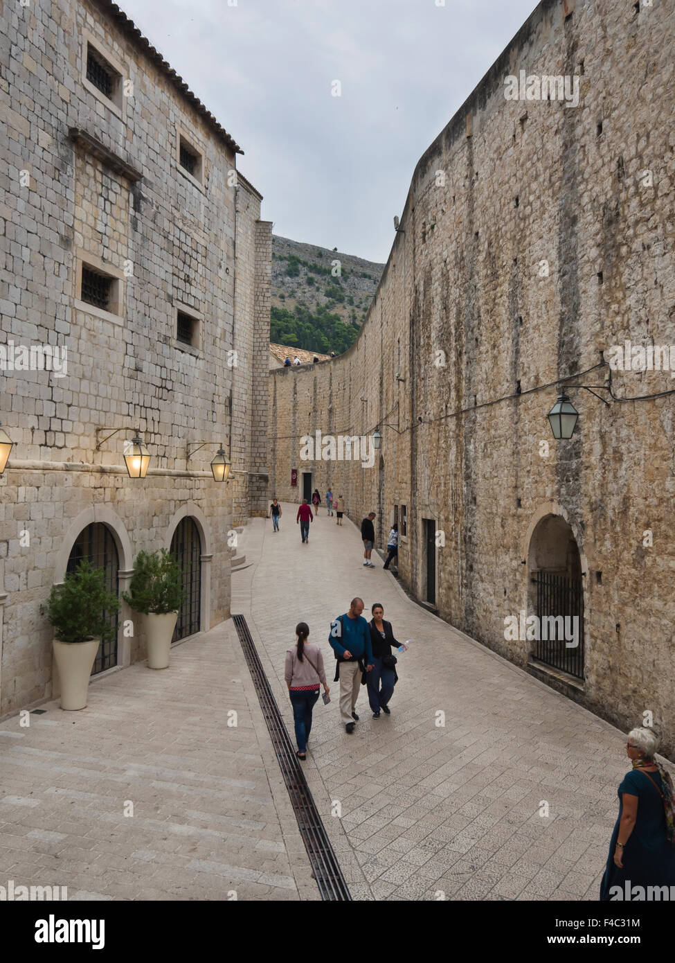 I turisti a camminare in una strada stretta lungo le mura di fortificazione nella città vecchia 'Stari Grad' in Dubrovnik Croazia Foto Stock