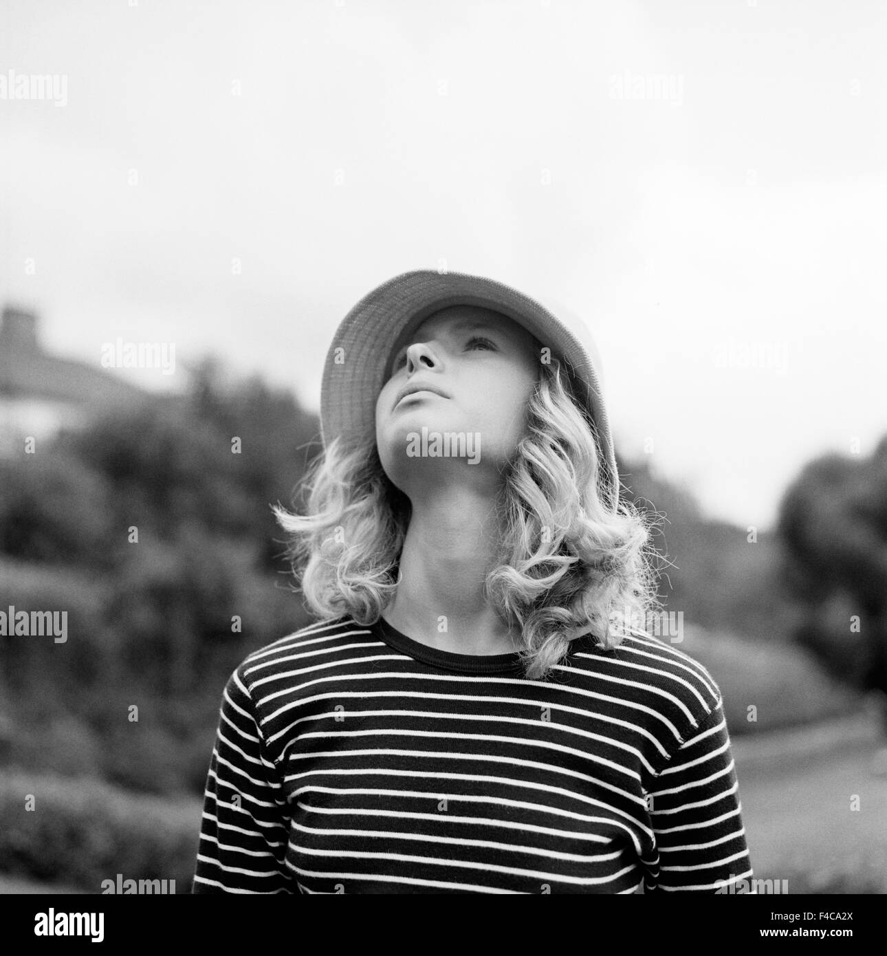 Una donna che guarda verso l'alto nel cielo. Foto Stock