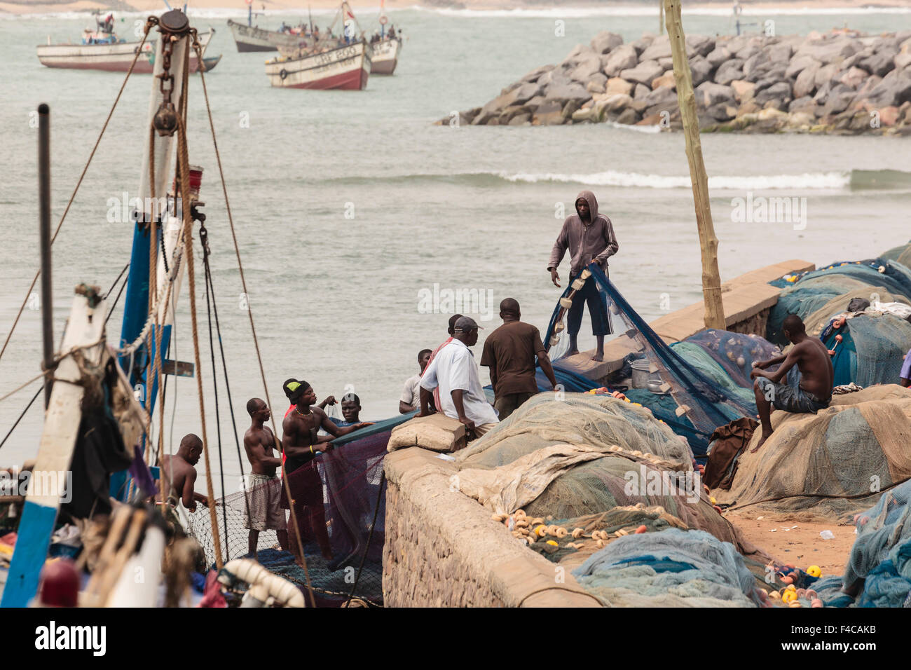 Africa Africa Occidentale, Ghana, Cape Coast, Elmina. Uomini al lavoro sulla rete da pesca. Foto Stock