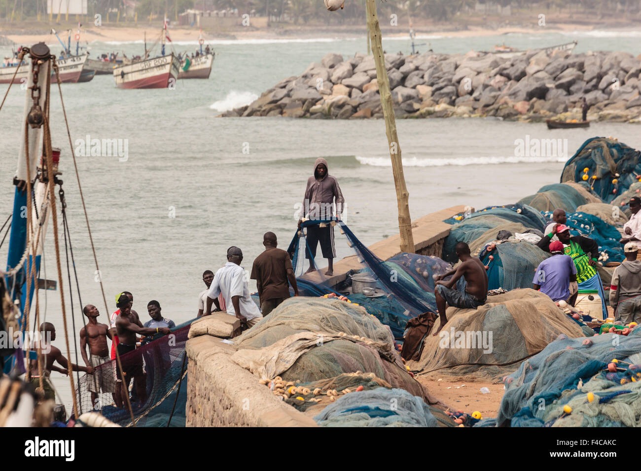 Africa Africa Occidentale, Ghana, Cape Coast, Elmina. Uomini al lavoro sulla rete da pesca. Foto Stock