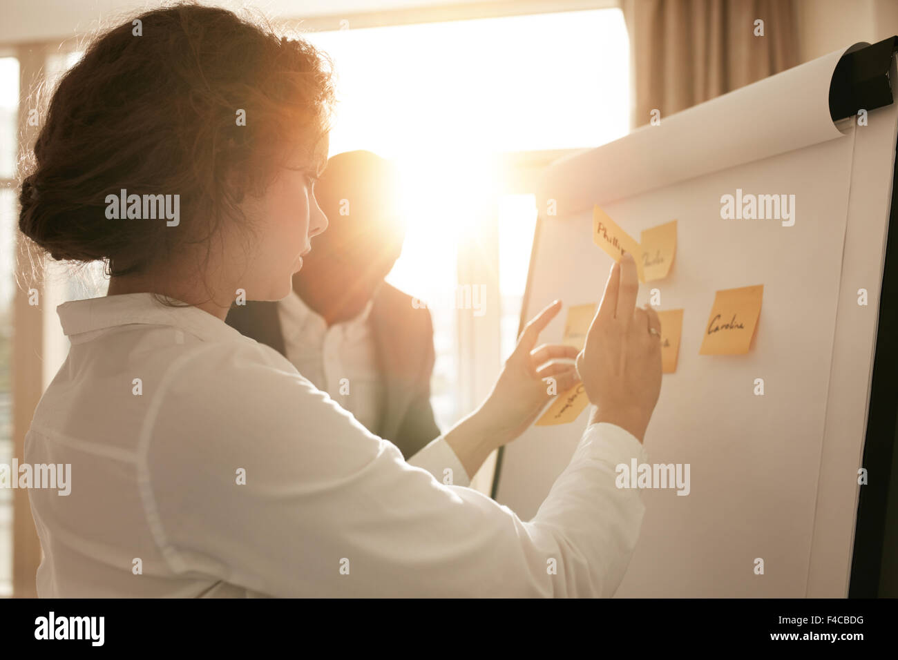 Colpo di giovani professionisti di brainstorming in un incontro. Imprenditrice imprenditore e presentare le loro idee sul whitebo Foto Stock