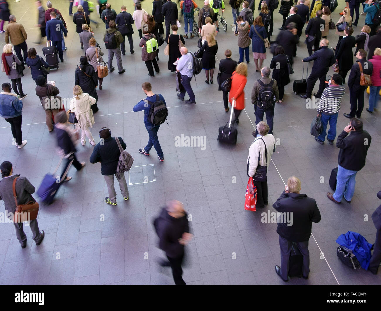 Passeggeri guarda le partenze pensione in Kings Cross stazione ferroviaria, Londra Foto Stock