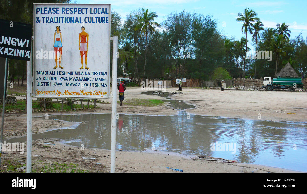 Tanzania, Zanzibar Nungwi, pannello pubblicità turistica chiedendo di vestire appropriatamente e il rispetto della cultura locale Foto Stock