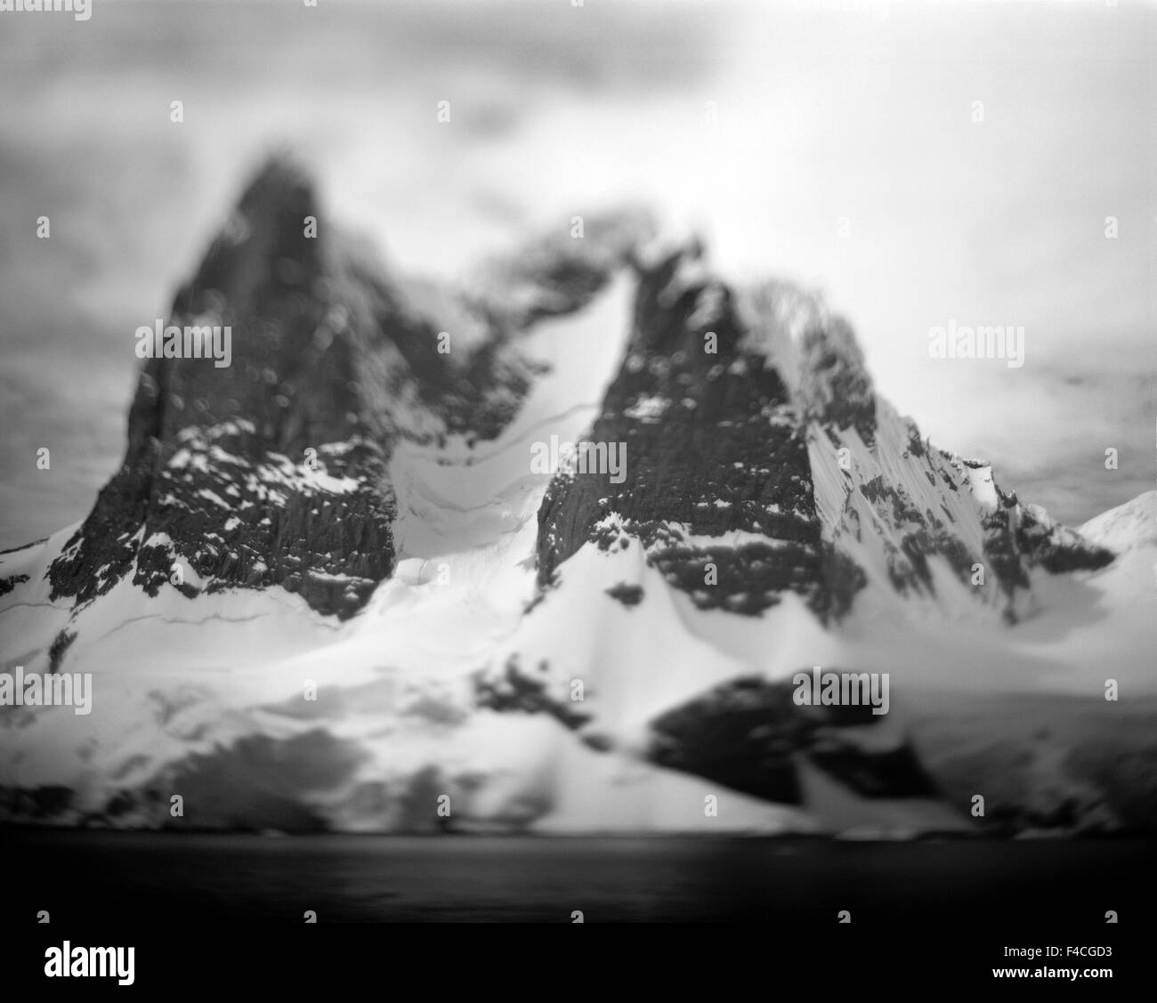 L'Antartide, offuscata immagine in bianco e nero dei picchi di montagna lungo Cape Renaud in Lemaire Channel in sole primaverile. Foto Stock
