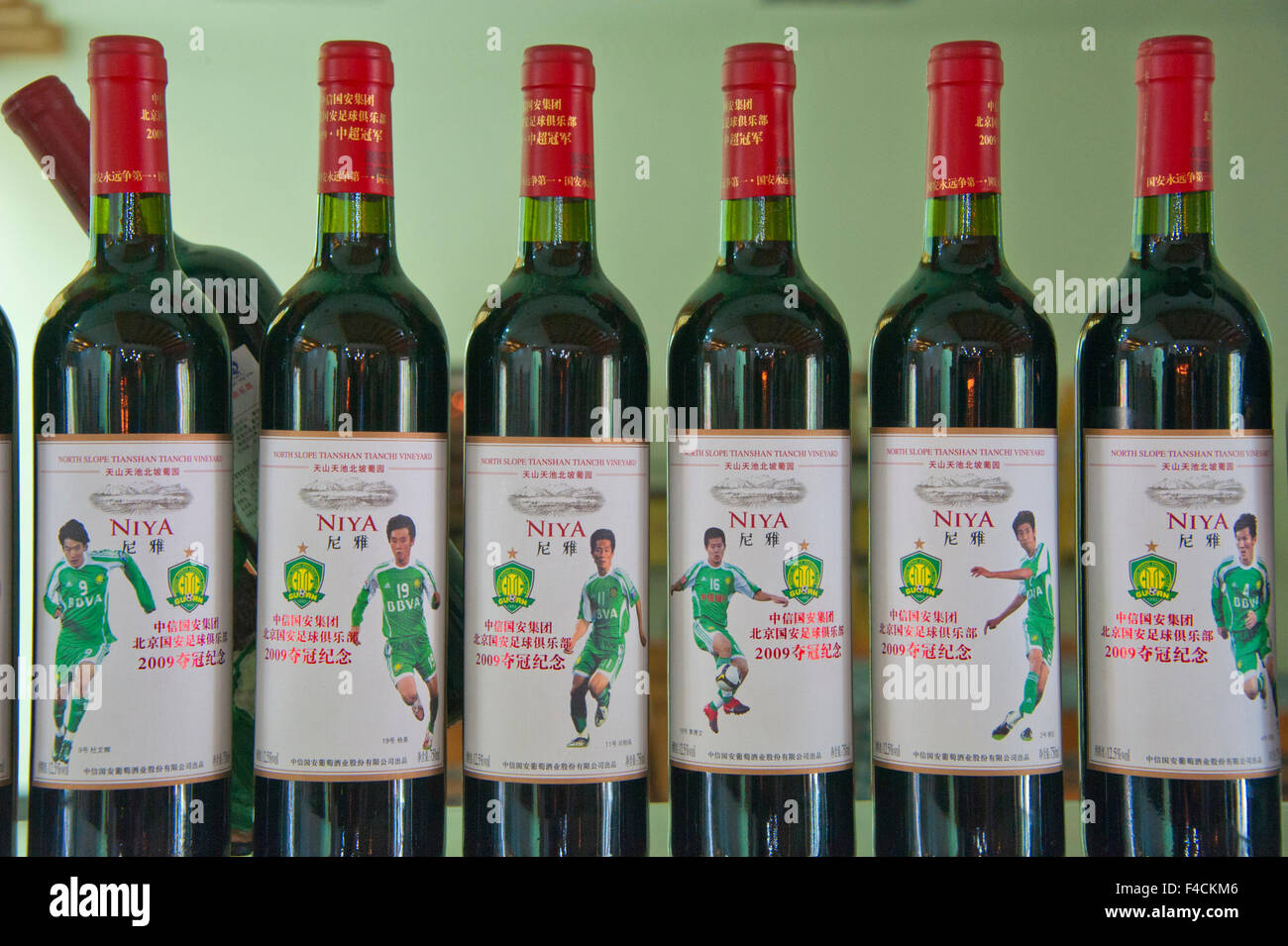 Cina, Xinjiang, Manas. Bottiglie di vino Niya etichettato con famosi ristoranti cinesi i giocatori di calcio visualizzati a Citic Guoan cantina. Foto Stock