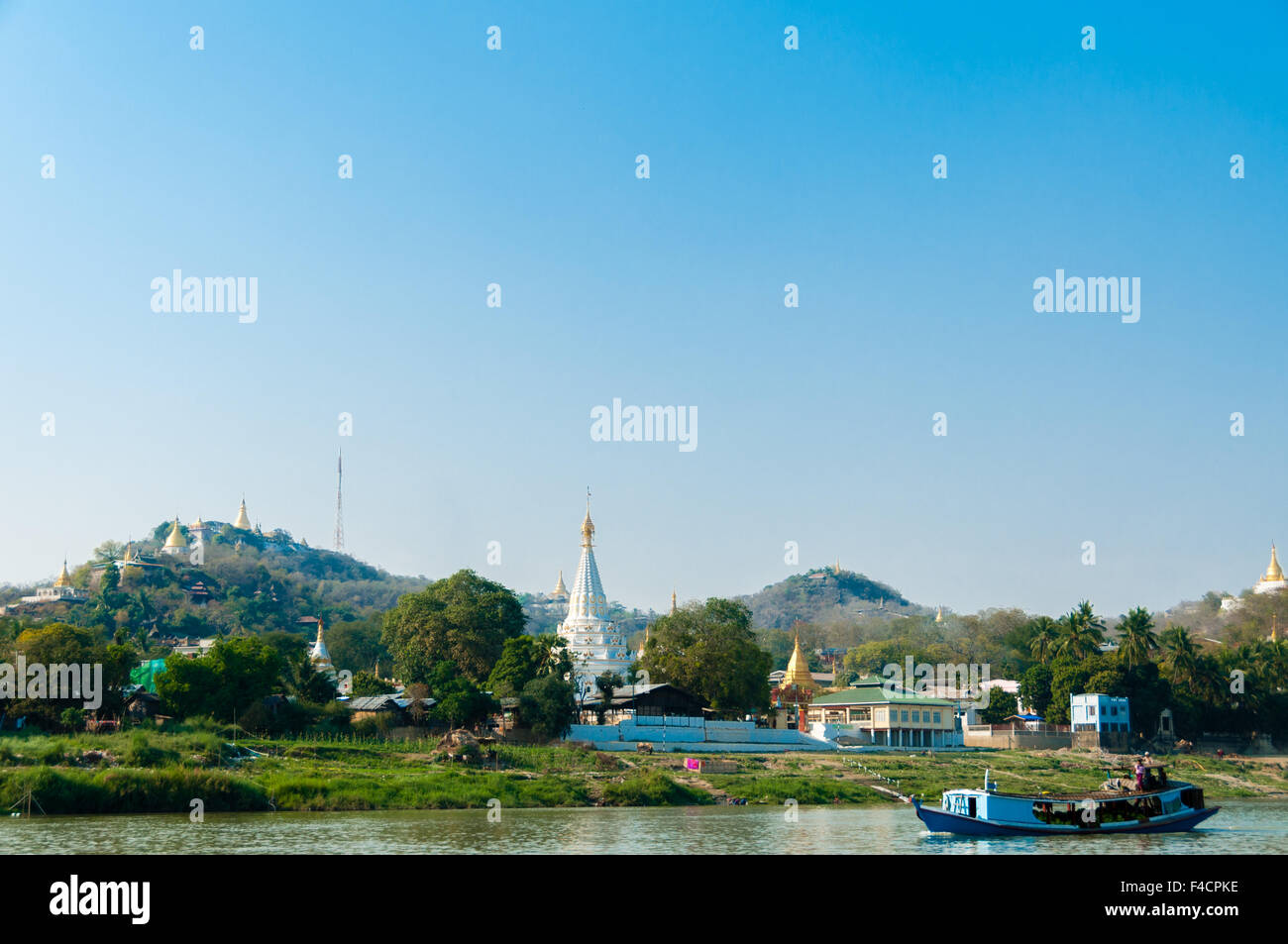 Barca sul fiume Irrawaddy con Pagoda e village Foto Stock