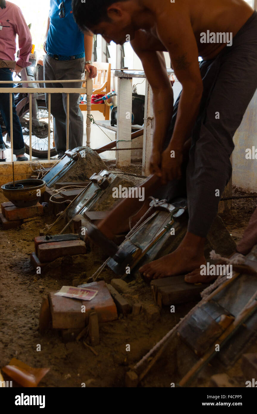 Giovane artigiano punzonatura di oro con un martello Foto Stock