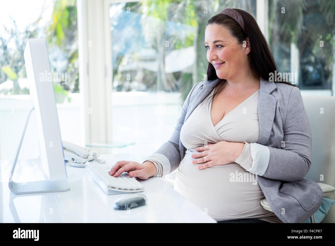 Incinta imprenditrice lavorando sul suo computer Foto Stock