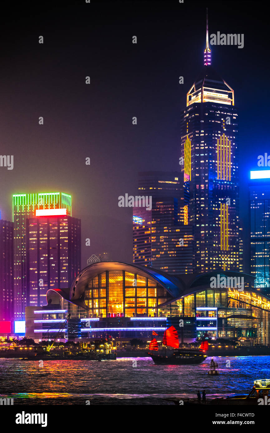 Vista della skyline di Hong Kong con un junk di notte. Foto Stock