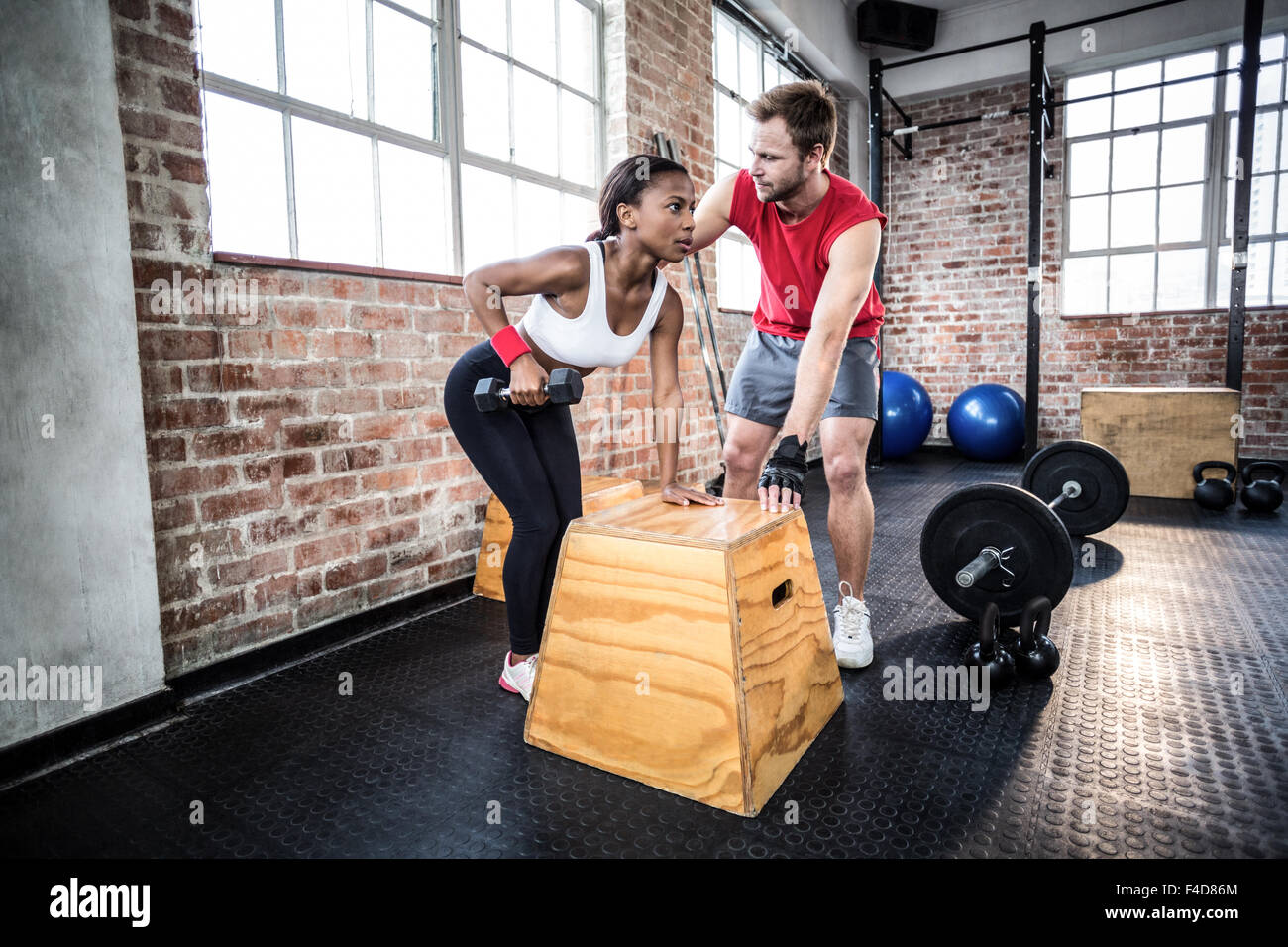 Donna muscolare il sollevamento di pesi con il suo trainer Foto Stock