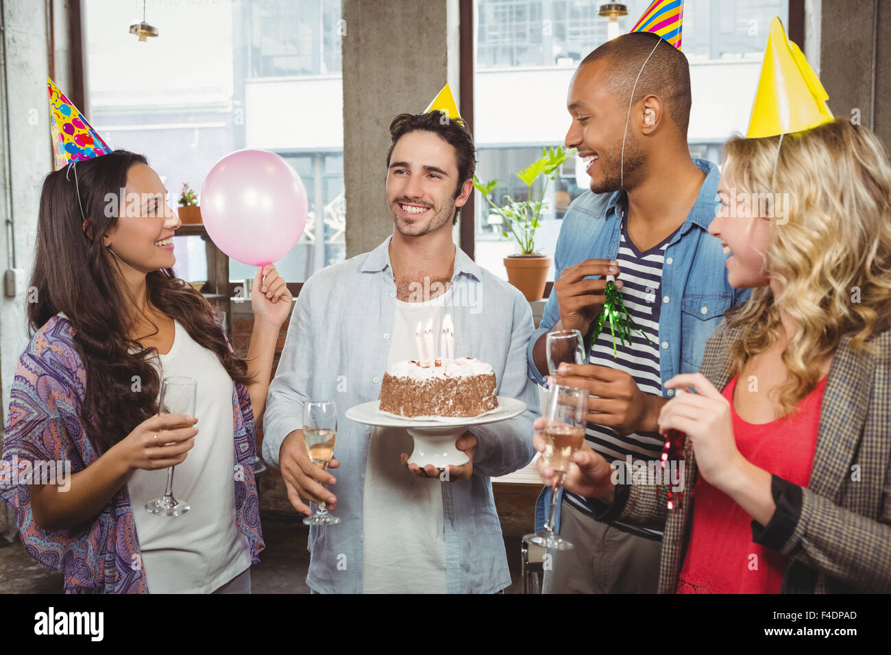I colleghi holding torta di compleanno e champagne flauti Foto Stock