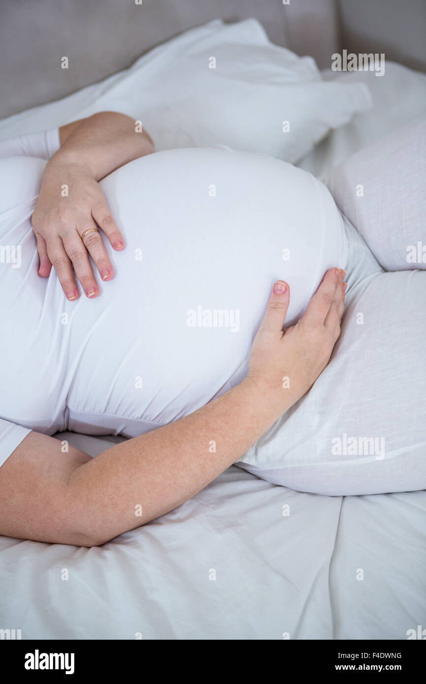 Bella donna incinta toccando il suo ventre Foto Stock