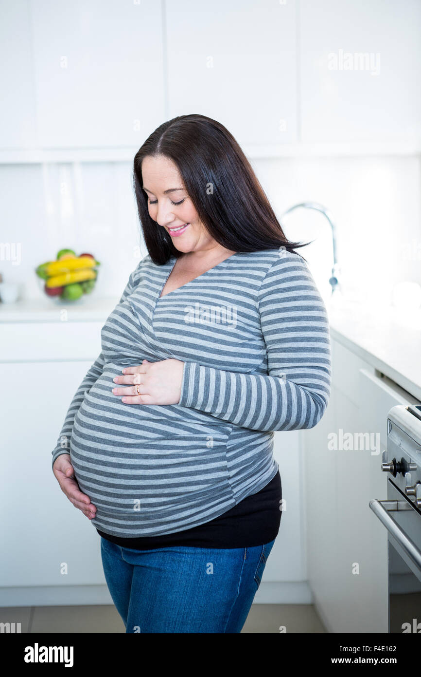 Donna incinta toccando il suo ventre Foto Stock