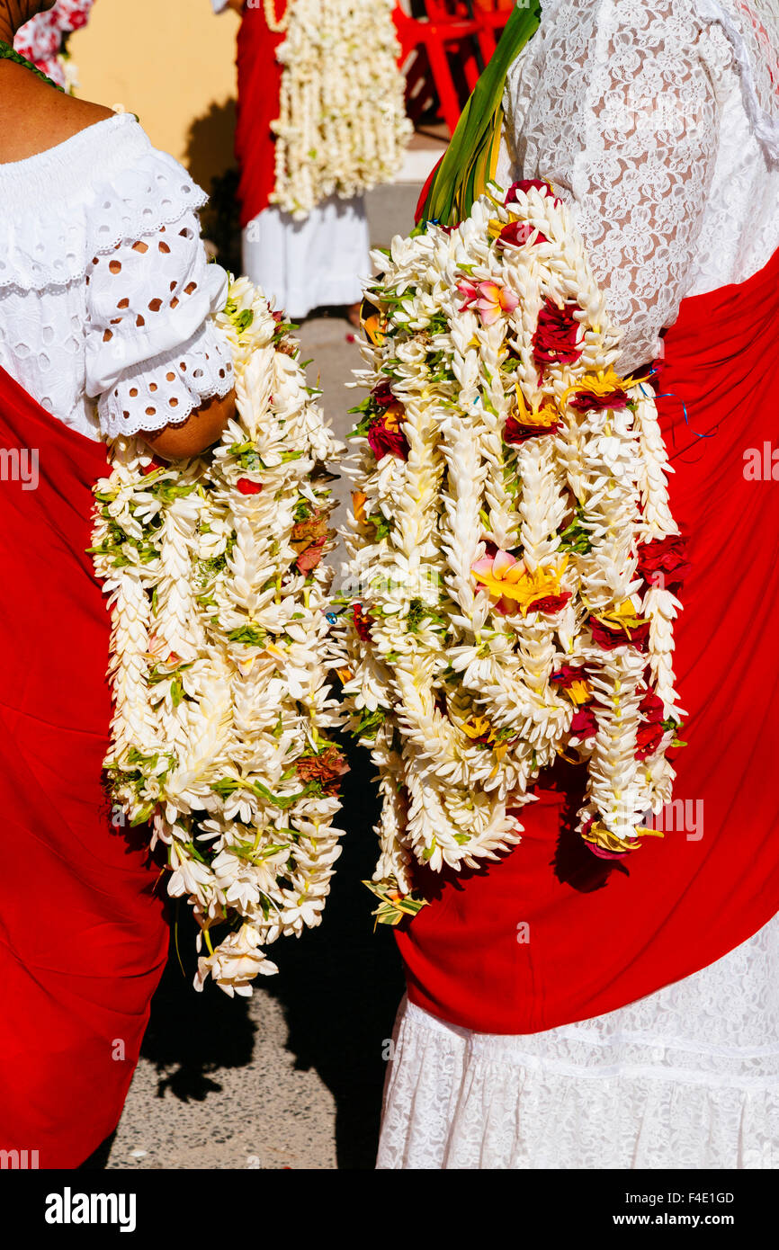 Oceano Pacifico, Polinesia francese Isole della Società, Huahine. Le donne nei tradizionali abiti in pizzo azienda tradizionale leis polinesiano, localmente denominata hels, fatta di Tahitian gardenie. Foto Stock
