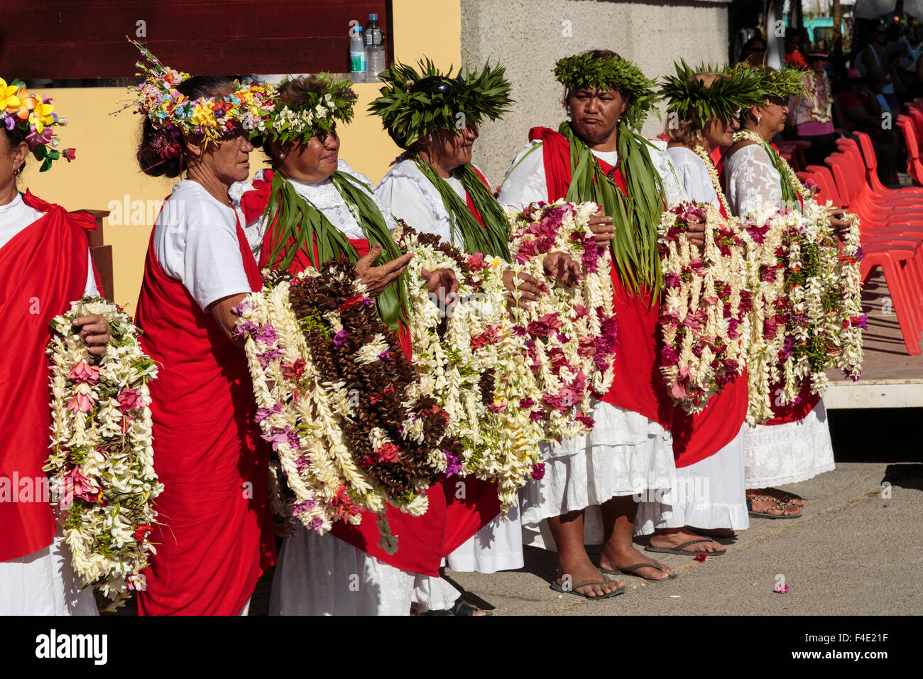 Oceano Pacifico, Polinesia francese Isole della Società, Huahine, tariffa. Donne locali riuniti in abito tradizionale azienda ilo per agli spettatori del festival. Foto Stock