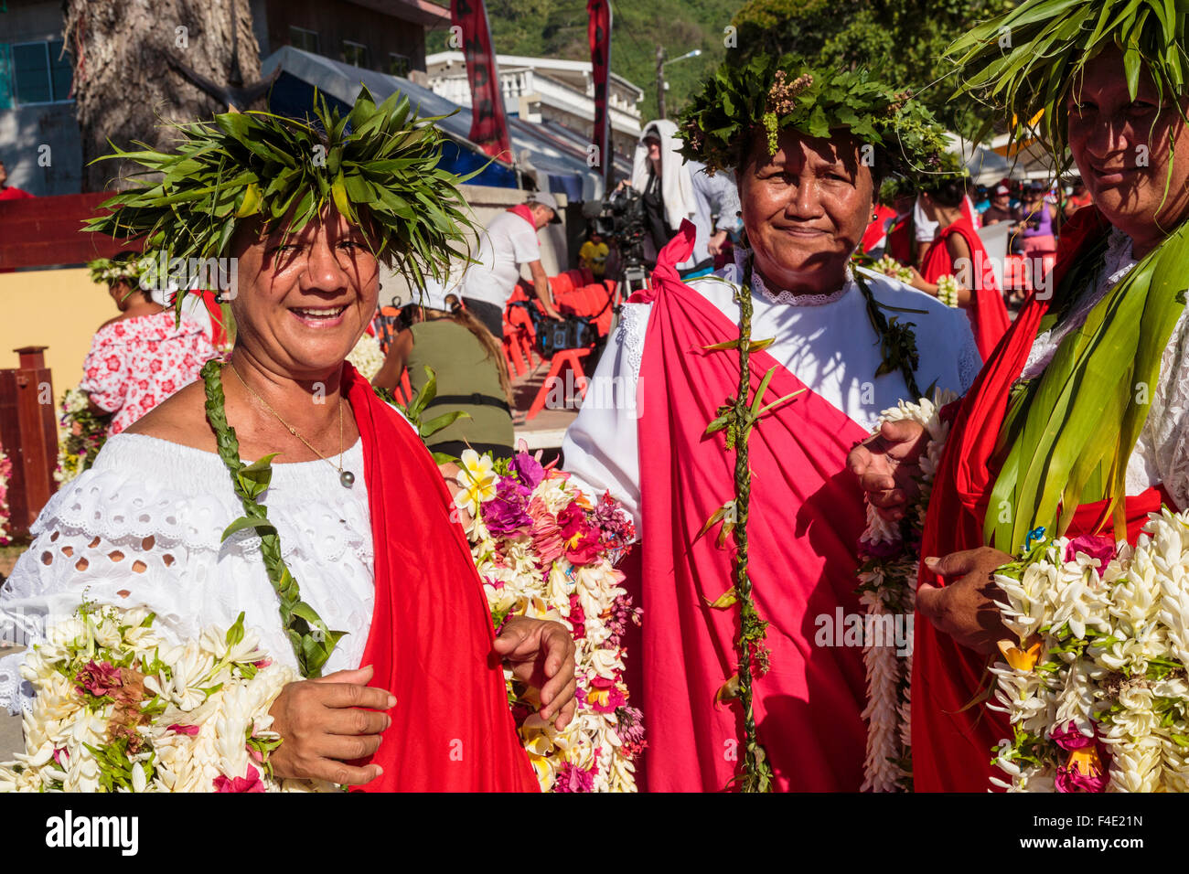 Oceano Pacifico, Polinesia francese Isole della Società, Huahine, tariffa. Donne locali riuniti in abito tradizionale azienda ilo per agli spettatori del festival. Foto Stock