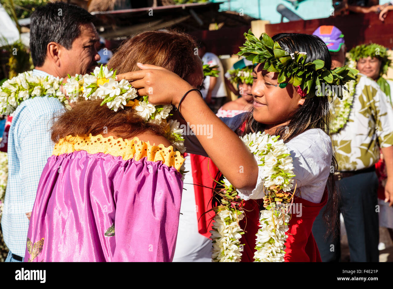 Oceano Pacifico, Polinesia francese Isole della Società, Huahine, tariffa. Donna mettendo lei tradizionale sul turista. Foto Stock