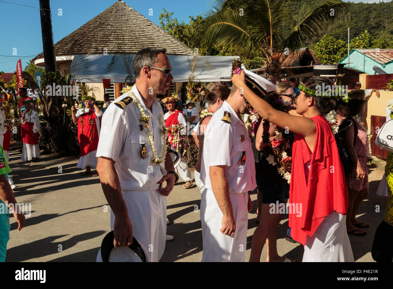 Oceano Pacifico, Polinesia francese Isole della Società, Huahine, tariffa. Donna mettendo lei tradizionale sul capitano della nave. Foto Stock