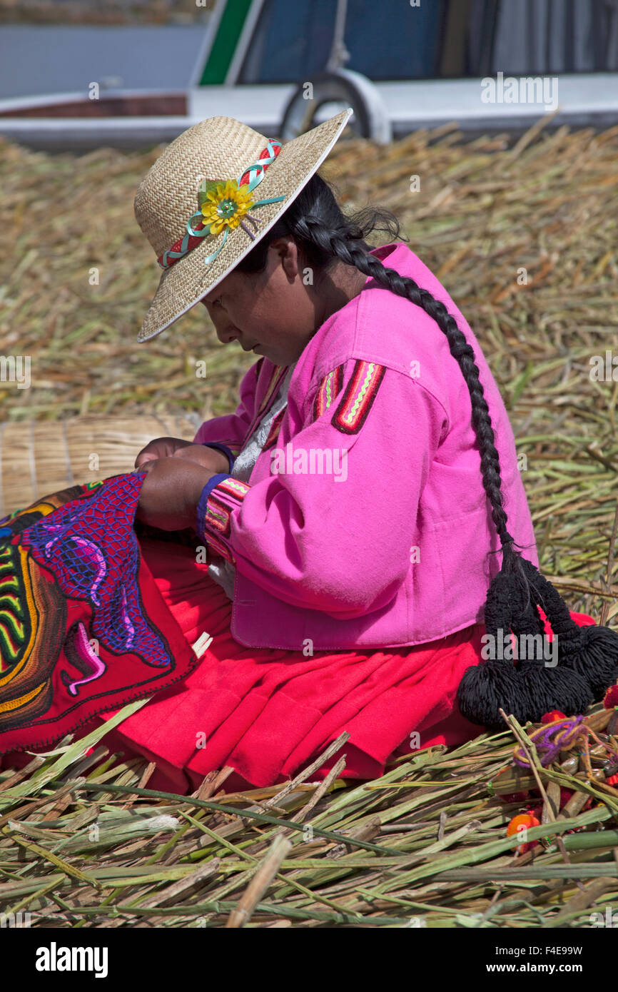 Sud America, Perù, Isole Uros. Uros donna facendo ricamo su floating reed le isole del lago Titicaca. Foto Stock