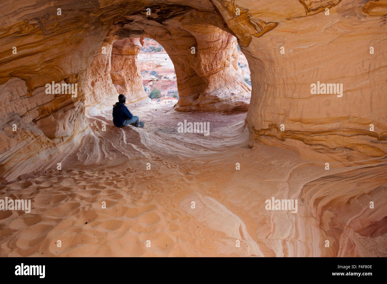 Riflettendo a Moqui Cavern, arenaria grotta di erosione, vicino a Kanab, Utah Foto Stock
