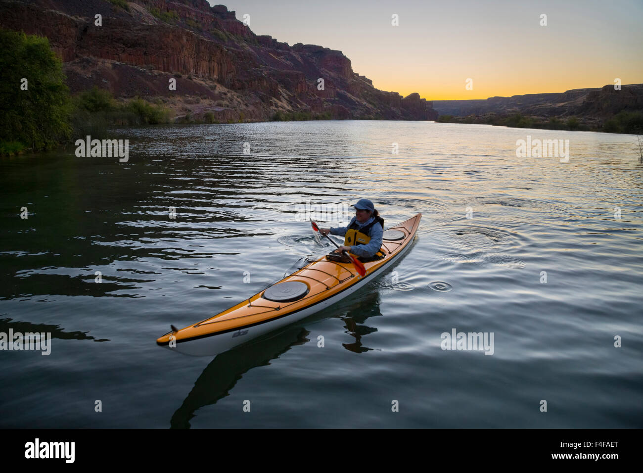 Stati Uniti d'America, nello Stato di Washington. Donna kayaker di mare sul kayak sul lago profondo vicino cade a secco, Grand Coulee, parte dell'alluvione di Missoula incanalato scablands (MR). Foto Stock