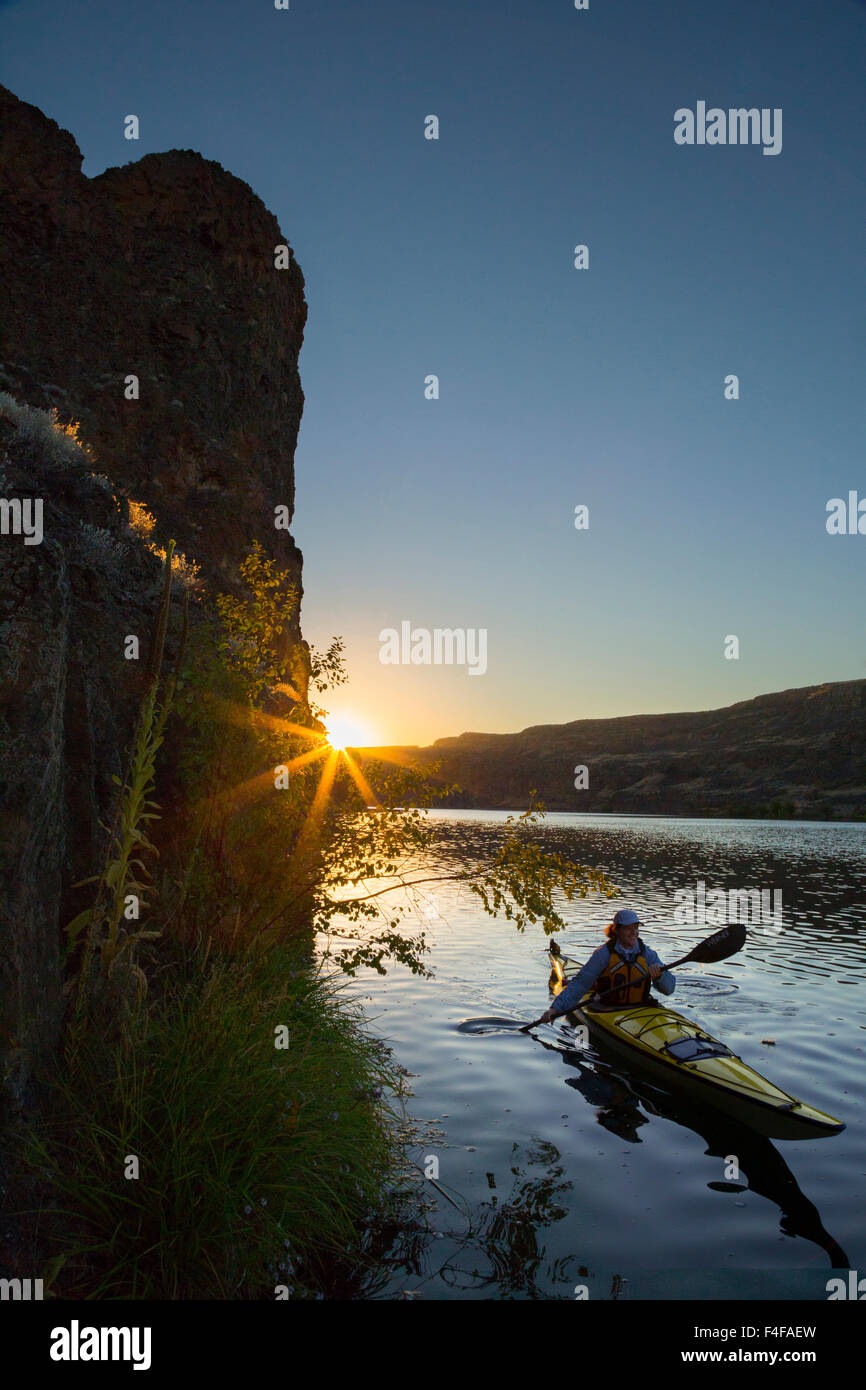 Stati Uniti d'America, nello Stato di Washington. Donna kayaker di mare sul kayak sul lago profondo vicino cade a secco, Grand Coulee, parte dell'alluvione di Missoula incanalato scablands (MR). Foto Stock