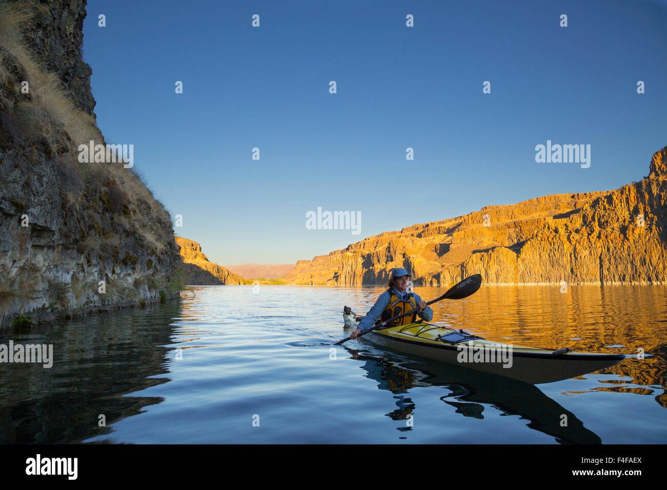 Stati Uniti d'America, nello Stato di Washington. Donna kayaker di mare sul kayak sul lago profondo vicino cade a secco, Grand Coulee, parte dell'alluvione di Missoula incanalato scablands (MR). Foto Stock