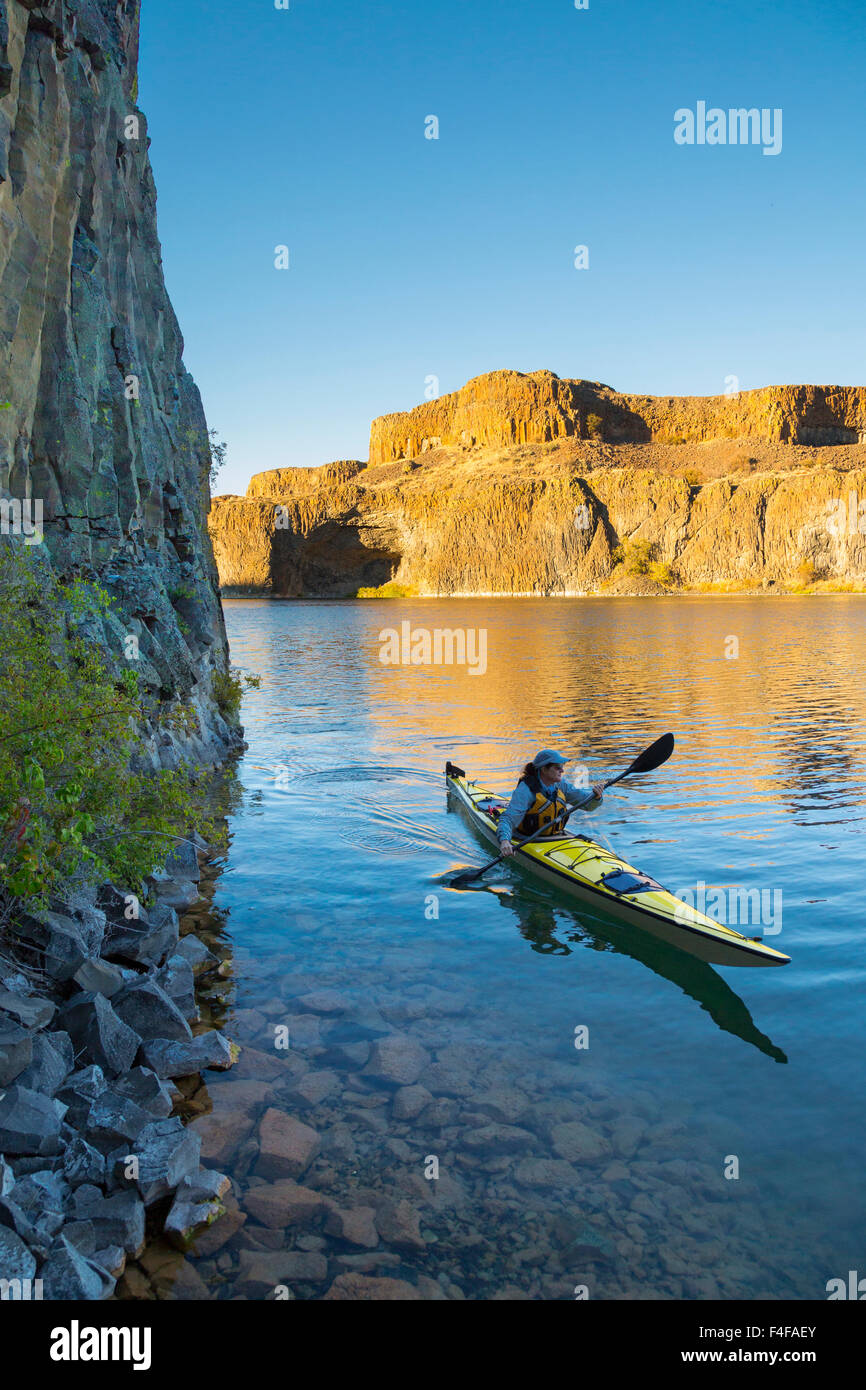 Stati Uniti d'America, nello Stato di Washington. Donna kayaker di mare sul kayak sul lago profondo vicino cade a secco, Grand Coulee, parte dell'alluvione di Missoula incanalato scablands (MR). Foto Stock