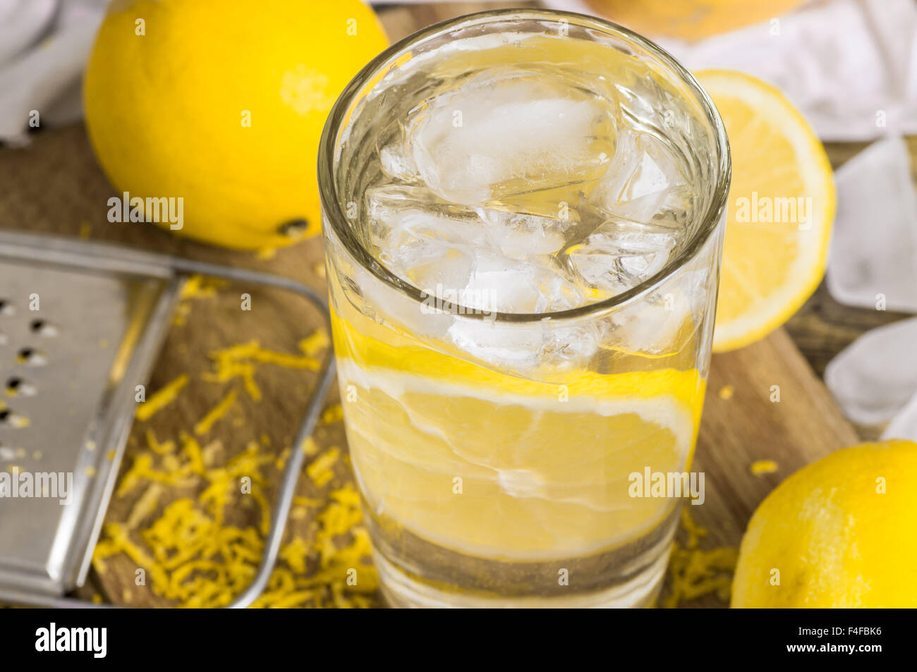 Bicchiere di acqua limone, scorza e succo di limone e ghiaccio Foto Stock