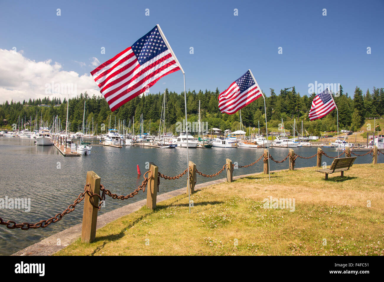 Stati Uniti d'America, nello Stato di Washington, Port Ludlow. Resort sul lungomare e la marina in ingresso al canale del cofano. 4 di luglio bandiera display. Foto Stock